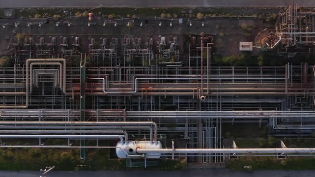 Aerial view of a complex network of industrial pipes, tanks, and structures creating a stark contrast, Setubal, Portugal.