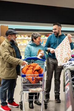 Family members choosing clothes and interacting happily in a supermarket