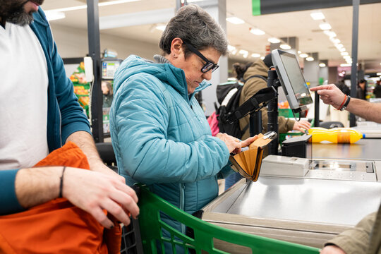 Customer selecting payment method from her wallet at the cash register