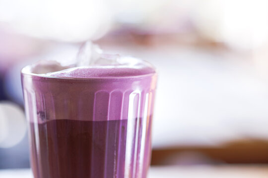 A refreshing ube iced coffee served in a clear glass