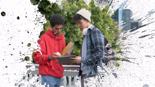 Diverse male friends meeting on raised walkway, plaid and red hoodie consulting tablet and envelope