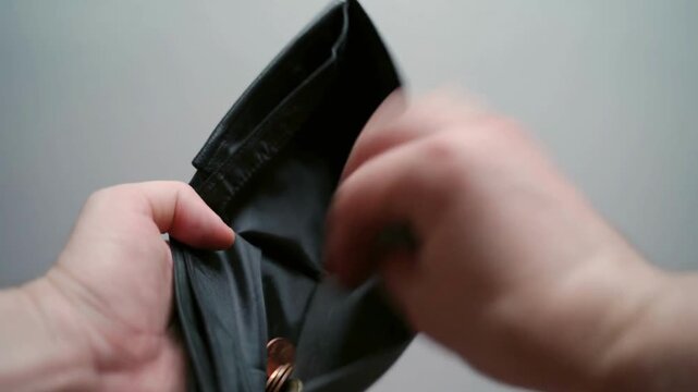 financial crisis money loss broke man with empty wallet with the last dollar bills and penny coins