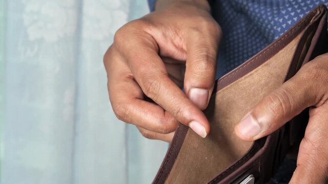 Closeup man opens an empty wallet with no money has nothing to pay. Poverty, crisis and unemployment concept