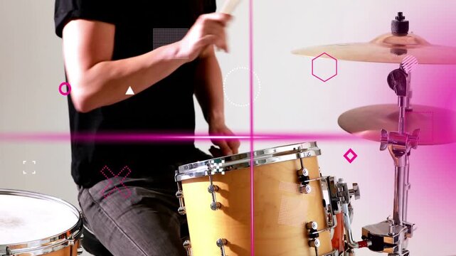 Drummer raising sticks and striking tom snare, causing magenta graphics mapping music rhythm