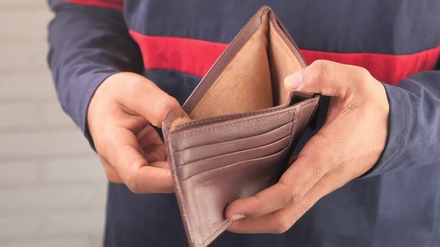 man looks into and showing empty wallet. Inflation money unemployment Bankruptcy finance background