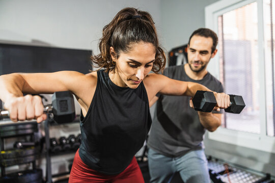 Woman performing functional training with personal trainer