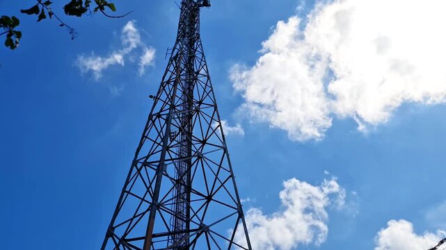 Tall Telecommunication Tower and Cellular Base Station Under Bright Sunny Sky