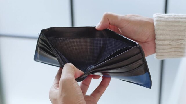 Closeup man opens an empty wallet with no money has nothing to pay. Poverty, crisis and unemployment concept