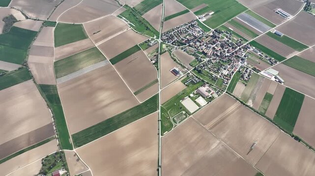 Aerial view of the patchwork fields surrounding Wintzenheim-Kochersberg, a charming village nestled amidst agricultural lands, Grand Est, France.