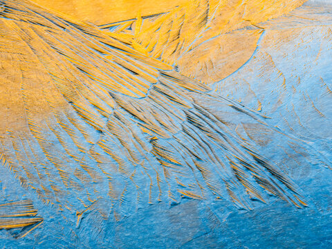 Abstract background of blue and yellow ice crystals forming patterns, creating a unique texture. Alveo Presena,Trentino,Tonale Pass,Italy.