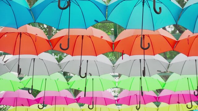 Walking under canopy of umbrellas in a park. Garden decor
