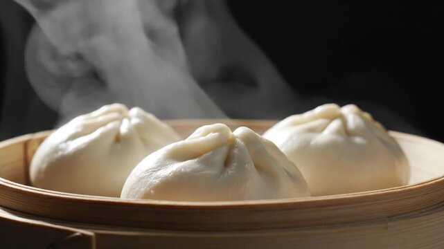 Steaming hot traditional Chinese dumplings being prepared in bamboo steamer with wisps of steam rising