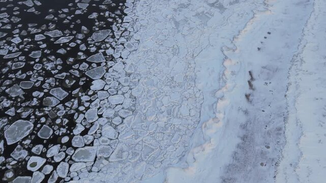 Aerial view of the frozen Baltic sea shows a mesmerizing contrast between the dark water and the jagged white ice floes, Mikoszewo, pomorskie, Poland.
