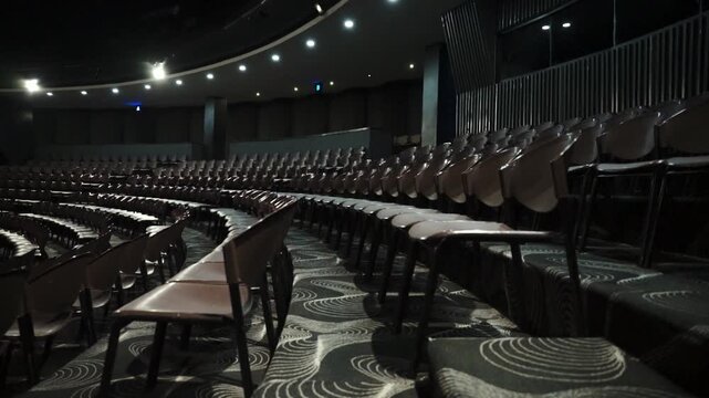 Dark auditorium with rows of empty chairs