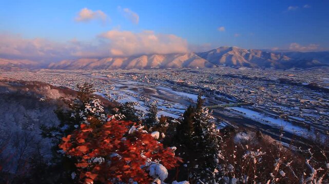 小牧城から望む朝の着雪した樹林と上田市街と四阿山