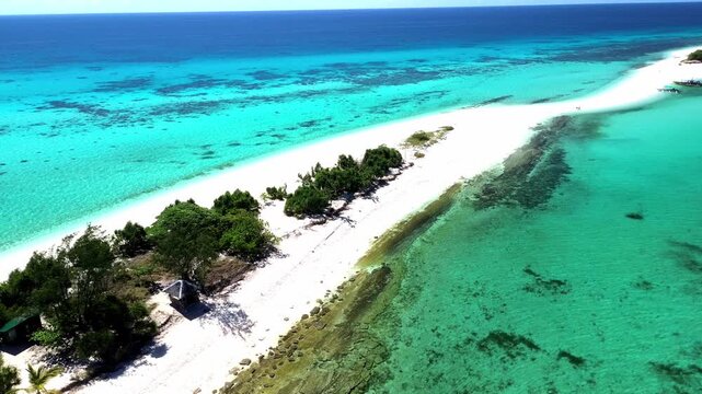 Aerial drone footage of a winding white sandbar with tropical outrigger boats in turquoise water.
