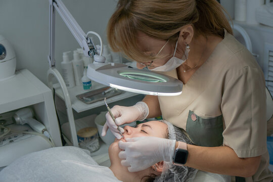 Facial Treatment, Skincare Clinic, Professional Dermaplaning: Expert performs facial treatment at beauty clinic using dermaplaning technique.