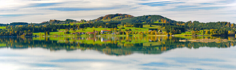 Fototapeta premium Im Allgäu spiegeln sich die Berge auf der Wasseroberfläche des Forggensee bei Füssen