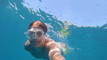 SELFIE: Man enjoys his vacation by snorkeling around the crystal clear ocean. © helivideo