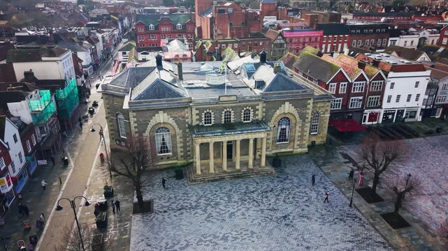 Drone aerial view of Salisbury Guildhall in Market Square showing surrounding streets, shops and pedestrians in Wiltshire England UK