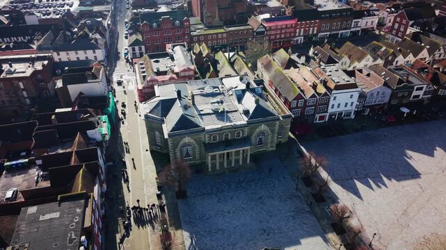 Aerial drone shot of Salisbury Guildhall and market square with surrounding historic buildings and long shadows in Wiltshire England UK