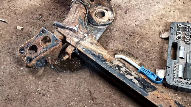 Rusted And Removed Vehicle Suspension Component Of A Rear Subframe. High Angle Shot
