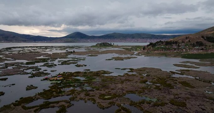 Drone scenery of floating islands on lake Titicaca Puno city on horizon. Travel Peru, landscape.