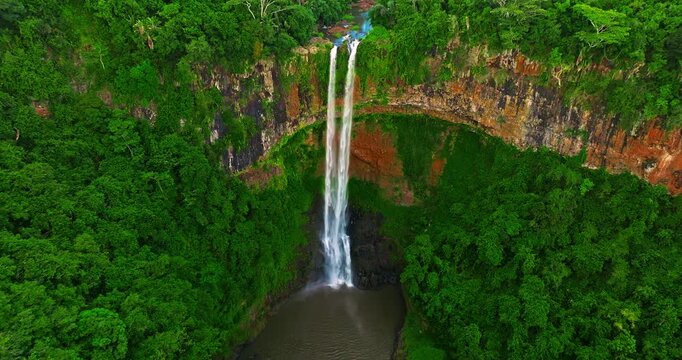 Aerial view of Chamarel Waterfall, plunging from verdant cliff into shadowy, the highest waterfall on the island, Mauritius island
