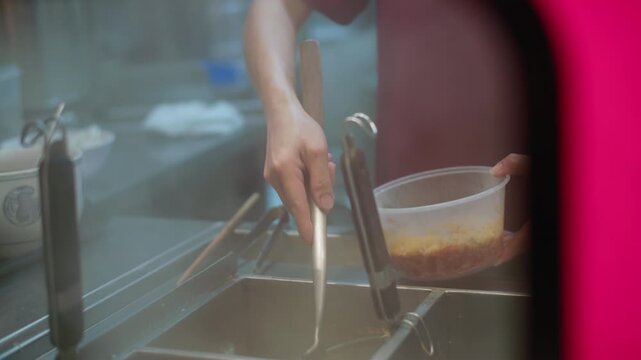 Fresh ramen noodles cooking in metal strainer in boiling broth, traditional Asian street food preparation