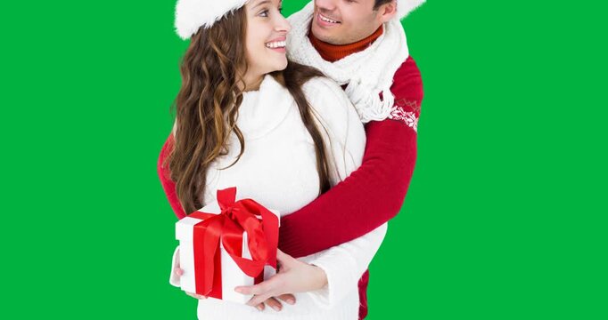 Caucasian couple wearing santa hats holding a christmas gift box against black background