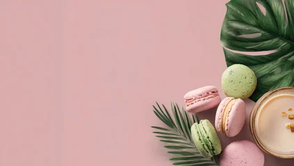 Fototapete Badezimmer Pastel macarons, tropical leaves, and a cup of coffee on a pink background  © Muh