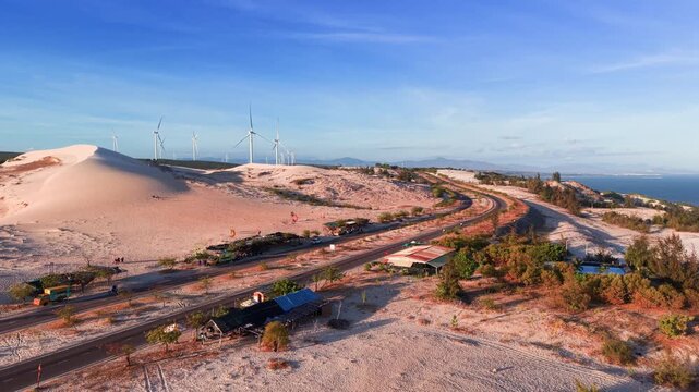 Exploring the white sand dunes in binh thuan vietnam with wind turbines and ocean view.