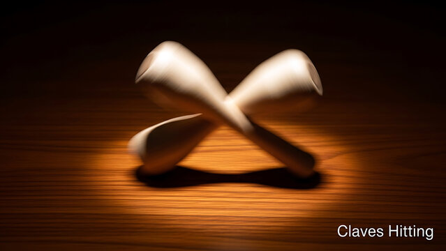 Two wooden claves hitting each other on a wooden surface with dramatic lighting  musical instruments in motion