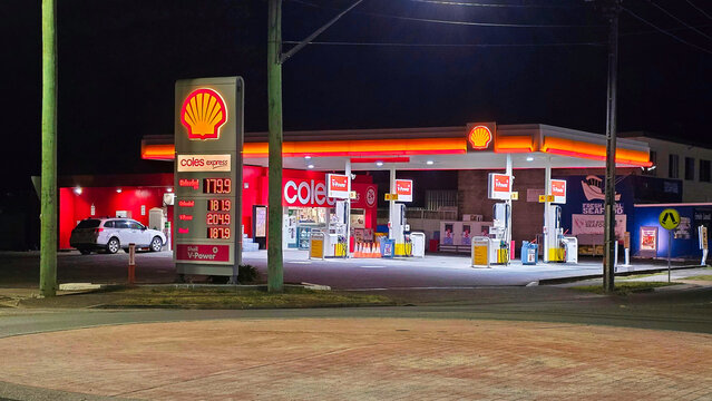 Gas station in Australia. Gasoline prices in 2024.Coles Express Shell service station at night with fuel prices displayed in a busy area