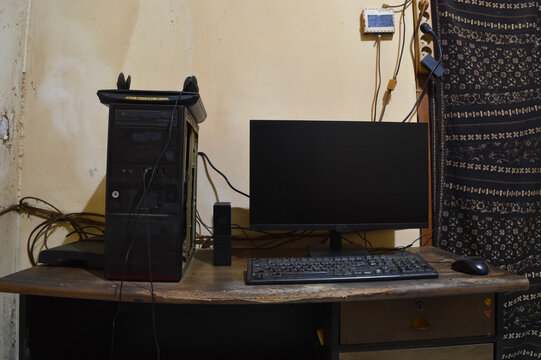 A straight-on eye level shot of a PC setup featuring an LED monitor, CPU tower, keyboard, mouse, flatbed scanner, and external hard drive arranged on a desk.