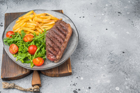 Juicy grilled beef culotte steak with potatoes and arugula salad, sirloin cap cut served for lunch or dinner