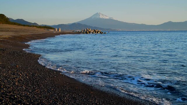 Mountain Fuji with wave crushing beach at sunrise, Suruga Bay, Shizuoka, Japan