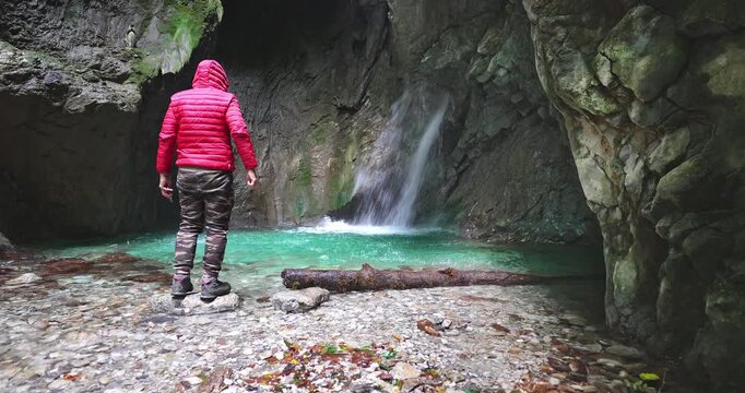 Boy explores an underground waterfall in the Dolomites