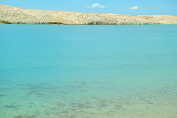 Obraz premium Pag Island, Croatia, Life on Mars Trail: Turquoise water and rocky coastline under blue sky