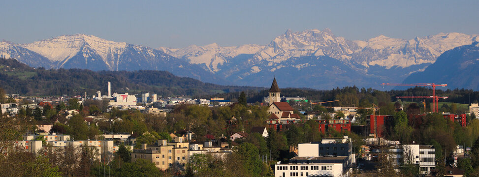 Wetzikon and snow covered mountain range, spring day in Zurich Canton, Switzerland.