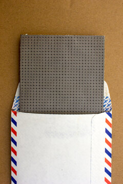 An old airmail letter isolated on a brown background.