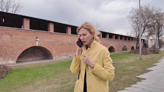 Frustrated woman holding smartphone while losing signal or connection in public park