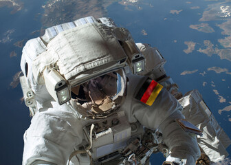 Close up view of German astronaut in outer space during a spacewalk with planet Earth in the background. Elements of this image furnished by NASA and ESA. © Bilal