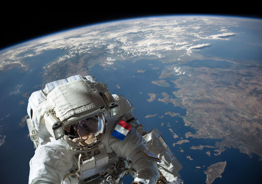 French astronaut in outer space during a spacewalk with planet Earth in the background. Elements of this image furnished by NASA.