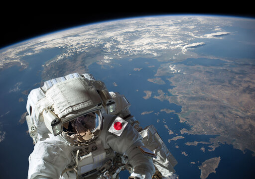 Japanese astronaut in outer space during a spacewalk with planet Earth in the background. Elements of this image furnished by NASA.