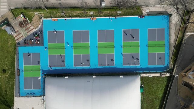Top Down Aerial View of People Playing Pickleball on Blue Courts