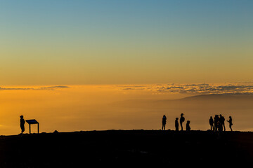 Naklejka premium Silhouettes of visitors watching sunset at Haleakala Maui Hawaii