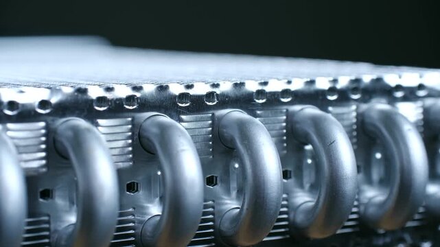 Close up view of an aluminum heat exchanger component, showing the detailed fins and tubing of the metal radiator system for industrial cooling and thermal management applications