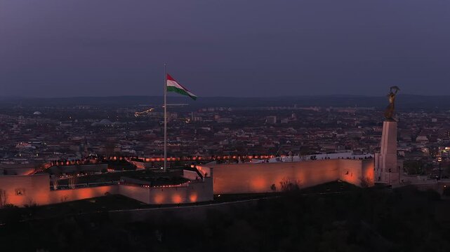 Renovated Liberty Statue, Szabads&aacute;g Szobor, Citadella visitor center and Hungarian flag on Gell&eacute;rt Hill in Budapest, Hungary.
