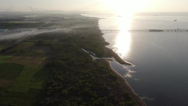 river delta along the narrow, white sandy beach of a rural town.  Drone, aerial